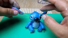 someone is making a small blue toy with scissors