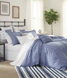 a bed with blue and white comforters in a bedroom