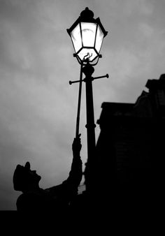 a black and white photo of a street light with the sky in the back ground