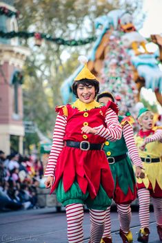 two people dressed as elves walking down the street