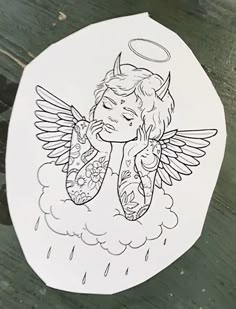 a drawing of an angel sitting on top of a wooden table