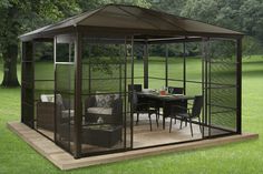 a gazebo in the middle of a grassy area with tables and chairs around it