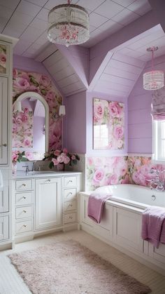 a bathroom decorated in pink and white with flowers on the bathtub, mirror, rug and chandelier