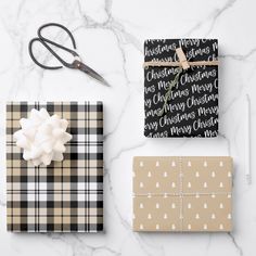 black and white wrapping paper on a marble surface with scissors, gift wrappers, and other items