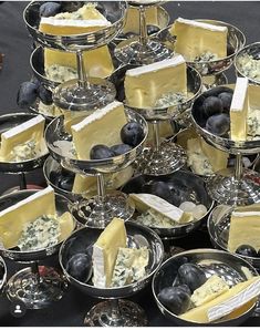 a table topped with lots of trays filled with cheese and blueberries on top of each other