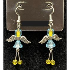 a pair of earrings with yellow and blue glass beads in the shape of an angel