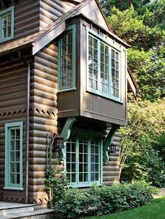 a wooden house with green trim and windows