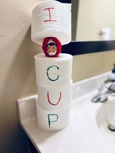 a stack of toilet paper sitting on top of a bathroom sink