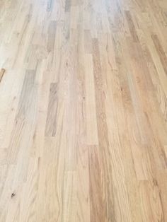 an empty room with hard wood flooring on the floor and a cat laying on the floor