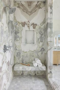 a walk in shower with marble walls and floor