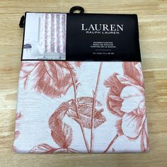 the packaging for lauren's bedding is displayed on a wooden table with an orange and white floral print