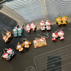 the hello kitty earrings are on display in front of a glass case with an inscription