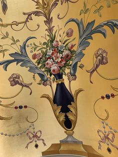 a vase filled with flowers sitting on top of a golden table cloth covered wallpaper