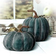 two blue pumpkins sitting on top of a table