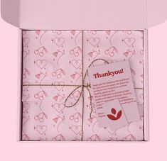 a pink gift box with a thank you note and heart - patterned wrapping paper on it