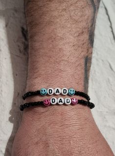 a man wearing a bracelet with beads that say dad