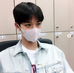 a man wearing a face mask in front of lockers