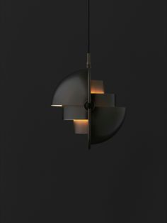 an image of a modern light fixture hanging from the ceiling in a dark room with black walls and flooring