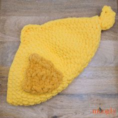 a yellow knitted hat on top of a wooden floor