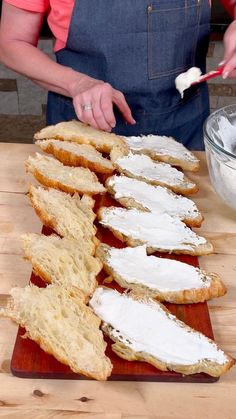 a woman is spreading cream cheese on bread