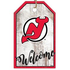 a red and white sign with the word welcome in black lettering on it, hanging from a rope