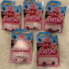 four pink barbie cars are in the package on the floor next to eachother