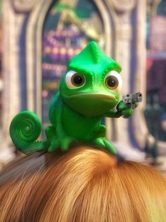 a green toy lizard sitting on top of a woman's head with her hair in pigtails