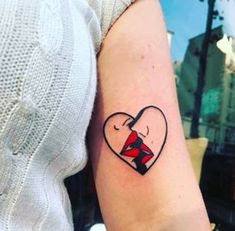 a woman with a heart shaped tattoo on her arm