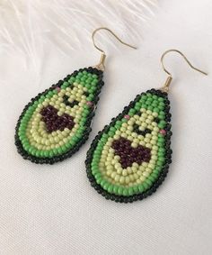 the beaded earrings are green and yellow with a face on it's side