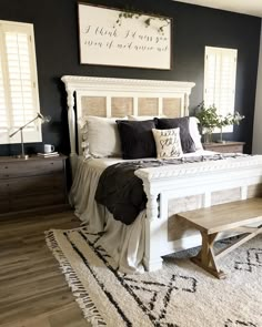 a bedroom with black walls and white furniture