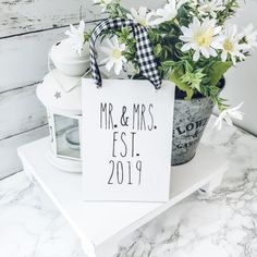 a sign that says mr and mrs sitting on top of a table next to flowers