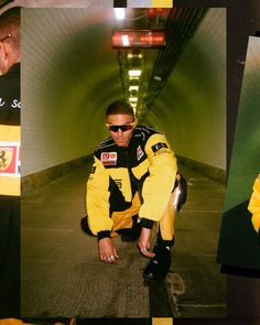 a man in yellow jacket and sunglasses crouching on the ground next to a wall