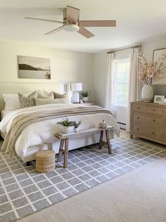 a bedroom with a bed, dresser and ceiling fan in it's center area