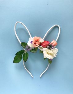 a heart shaped headband with flowers and leaves on blue background for valentine's day