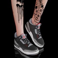 a woman's leg with tattoos and sneakers on it, next to a black background