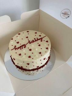 a birthday cake with white frosting and red sprinkles in a box