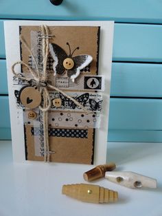 a close up of a greeting card with buttons and paper on the front, tied in twine