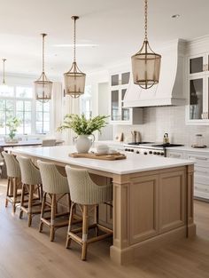 a large kitchen with an island and lots of chairs