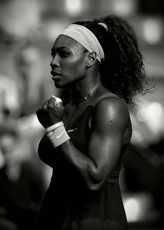 a black and white photo of a woman holding a tennis racquet