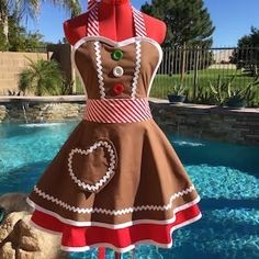 a dress made to look like a gingerbread girl standing in front of a pool