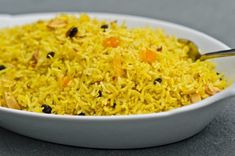 a white bowl filled with yellow rice and raisins