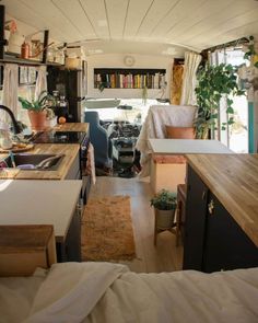 the interior of a camper with lots of storage space and plants on the counter