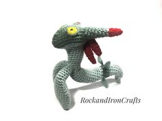 a crocheted toy is holding a toothbrush in it's mouth while standing on its hind legs