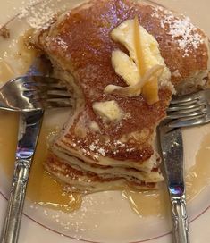 a plate topped with pancakes covered in butter and syrup