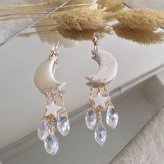 a pair of earrings with stars and moon on them