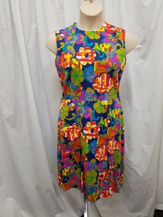 Vintage 1960s Liberty Circle Bright Floral Thick Cotton Shift Mini Dress w Pocket - Garden Party Dress - Sleeveless Summer Sundress, Collector.  Dress is in MINT vintage condition.  Dress has a crew neckline, darts on the bust, 1 front pocket, an adorable front pleat on the skirt (see pics), and a back zipper closure.  Gorgeous bright print! Measurements: waist 32, bust 38, length 39, shoulder to shoulder 15, neck opening 6 1/2, hem 1 1/2 inches. Sleeveless Green Dress With Retro Print, Green Sleeveless Dress With Retro Print, Sleeveless Retro Print Dress For Garden Party, Sleeveless Dress With Retro Print For Garden Party, 1970s Sleeveless Floral Print Dress, 1970s Style Sleeveless Floral Print Dress, Retro Sleeveless Lined Dress, Multicolor Sleeveless Mod Dress, Mod Sleeveless Lined Dress