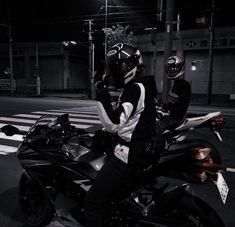 two motorcyclists are sitting on their motorcycles at night