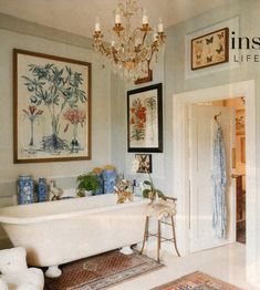 a bathroom with a claw foot tub and pictures on the wall above it that says inspire life