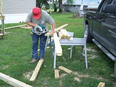 a man with a circular saw is working on some wood planks in the yard