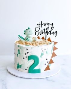 a two year old birthday cake decorated with dinosaurs and the number 2 on it's top